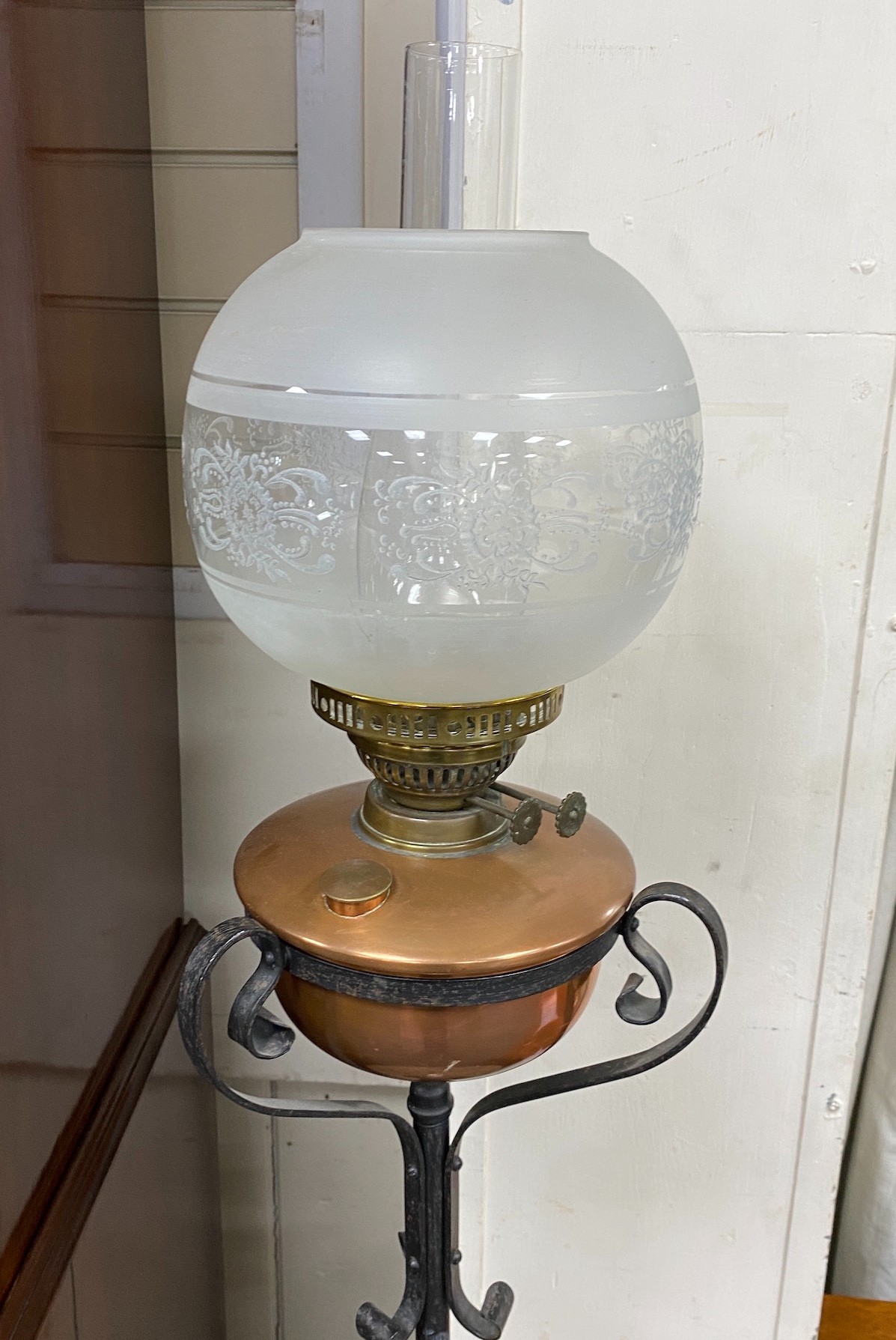 An Edwardian wrought iron and copper telescopic standard lamp with alabaster tier